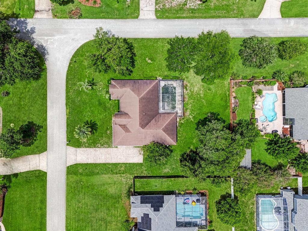 An aerial view shows a residential house with a pool enclosure and a large yard — 508 BROKENSHIRE DRIVE, DEBARY, FL