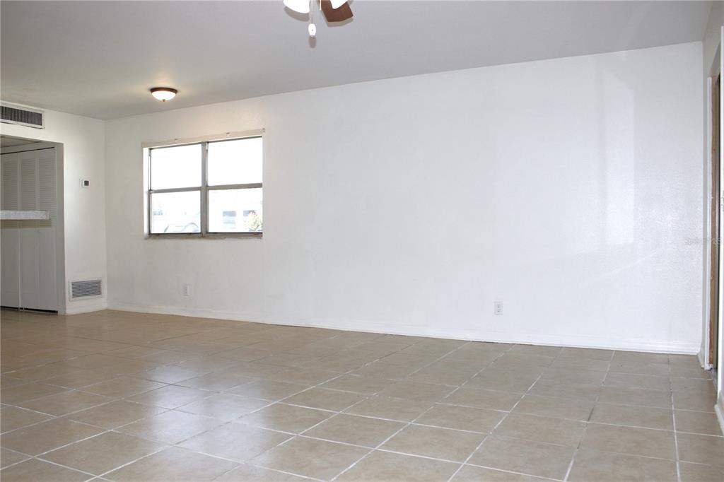 An empty room with white walls, tan tile flooring, and a single window — 101 CAMBRIDGE TRAIL UNIT 194, SUN CITY CENTER, FL