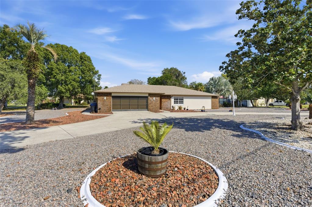 A single-story house with a brown brick facade and a large gravel front yard — 8123 RIVER COUNTRY DRIVE, WEEKI WACHEE, FL