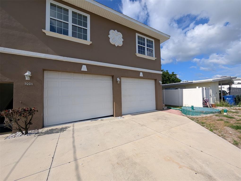 The exterior of a two-story house features a two-car garage and a concrete driveway — 3006 HAWTHORNE STREET, SARASOTA, FL