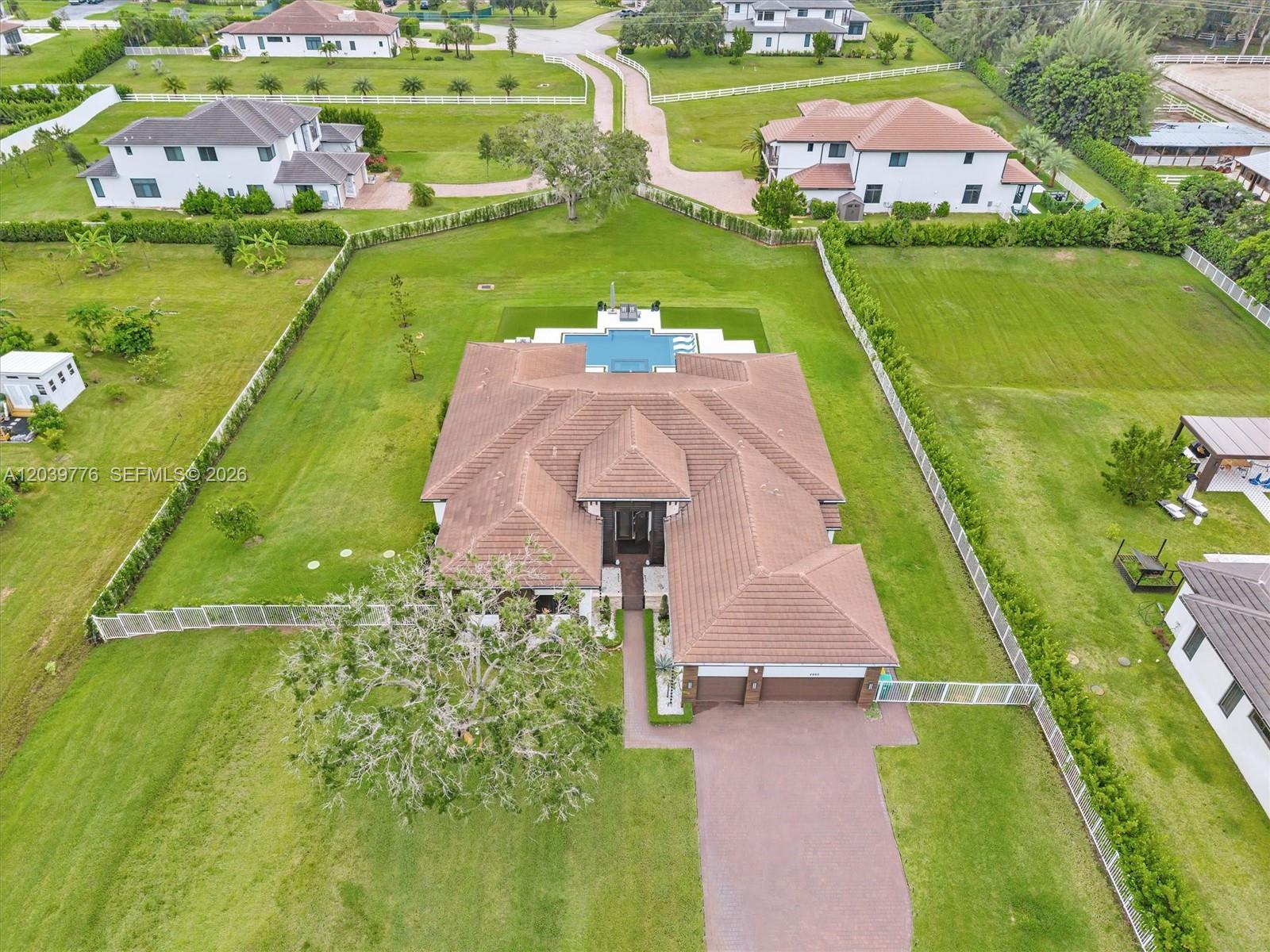 An aerial view shows a house with a brown tiled roof, pool, and large yard — 4980 SW 159th Ave, Southwest Ranches FL 33331, SOUTHWEST RANCHES, FL