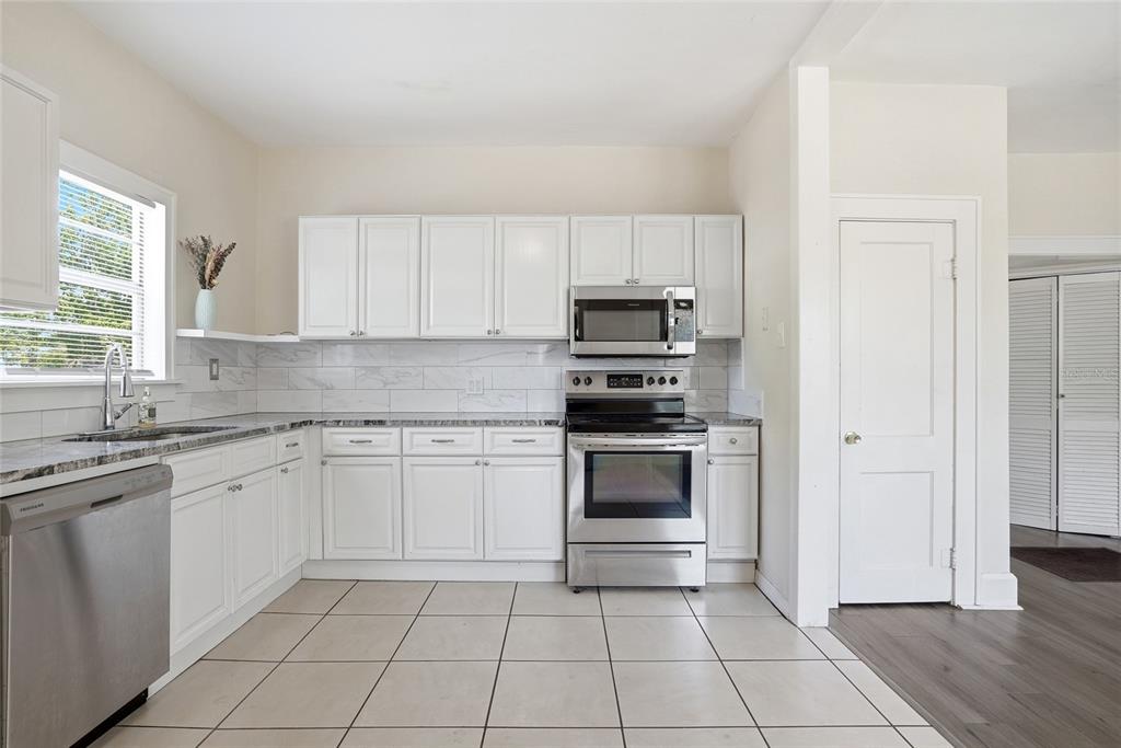 A living room features a brick fireplace, white sofa, wooden coffee table, and ceiling fan — 4026 4TH AVENUE S, ST PETERSBURG, FL