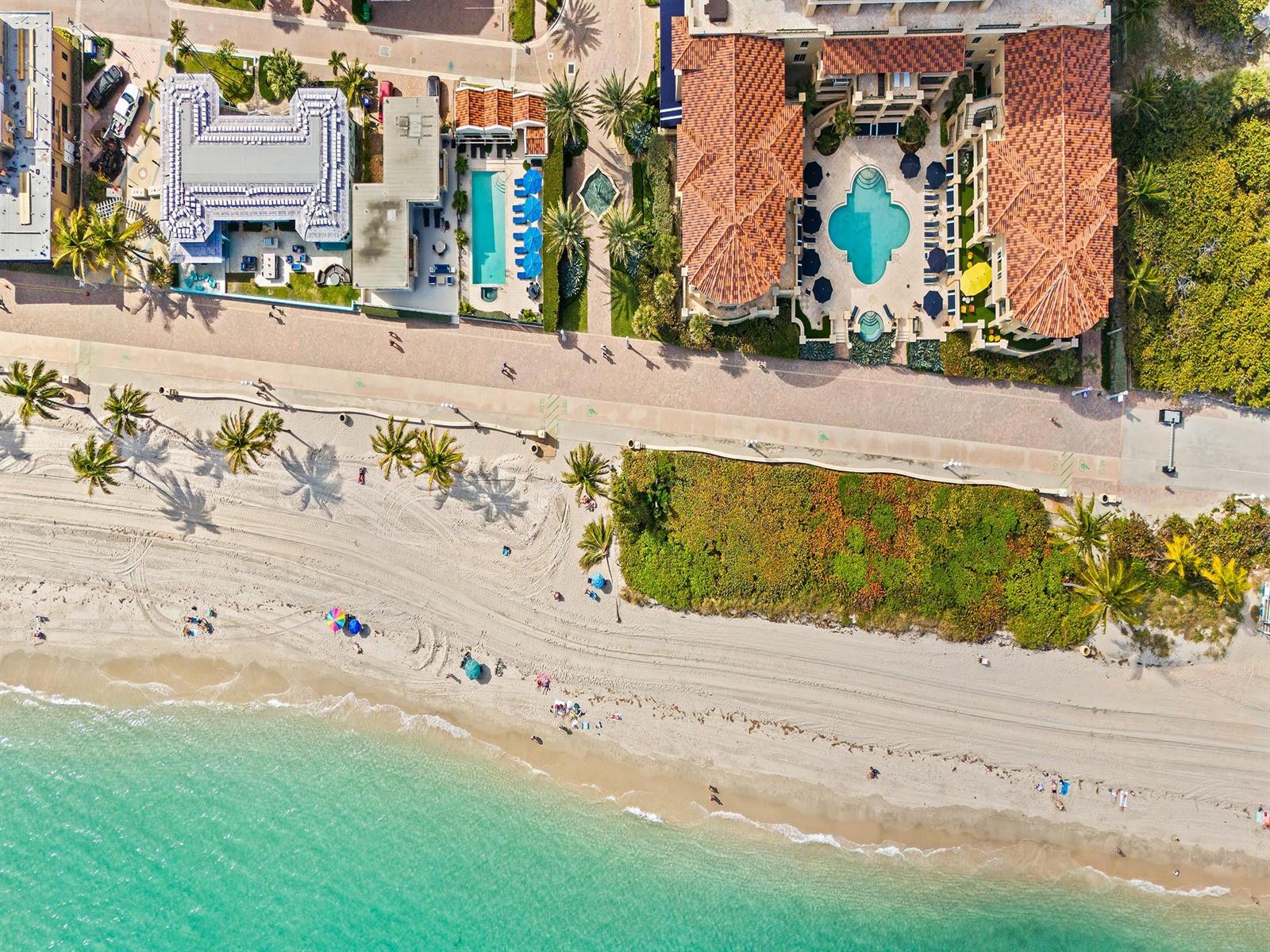 Aerial view of a beachfront resort with a swimming pool, palm trees, and sandy beach — 3415 N Ocean Drive # 505, Hollywood FL 33019, HOLLYWOOD, FL