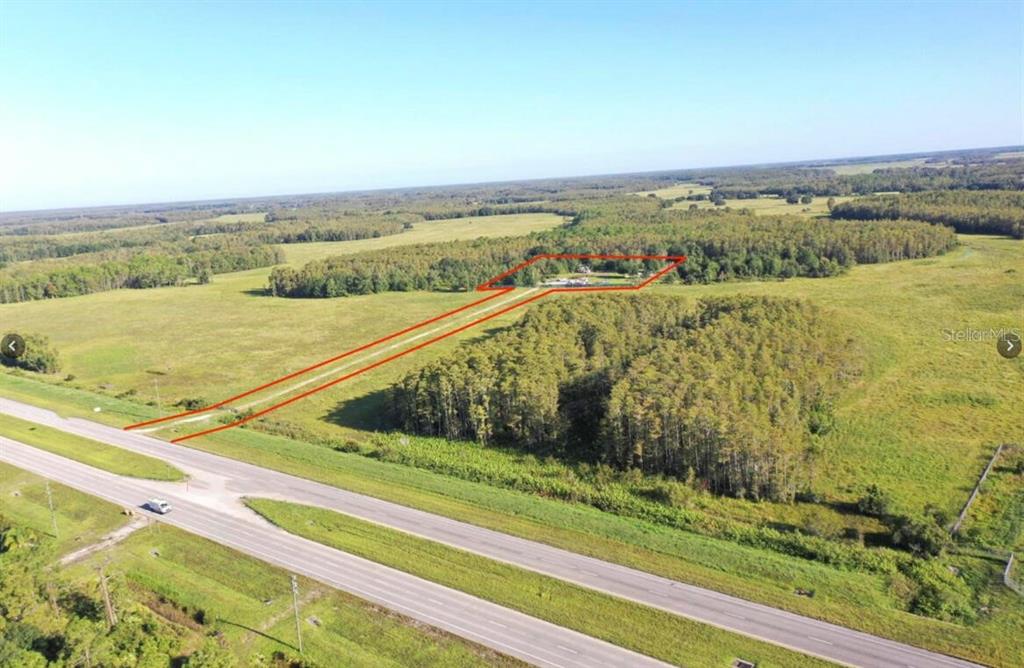 An aerial view shows a rural property with a house outlined in red near a highway — 9699 E IRLO BRONSON MEMORIAL HIGHWAY, ST CLOUD, FL