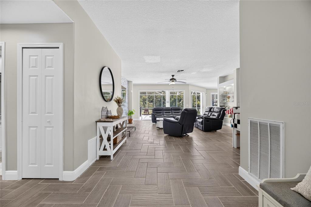 A view of a living room with tile flooring, a white console table, and furniture — 12419 RIVERGLEN DRIVE, RIVERVIEW, FL