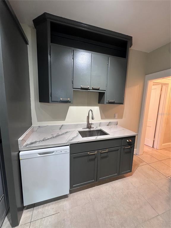 A kitchen area features dark gray cabinets, a white dishwasher, and a marble-patterned countertop — 2610 CENTRAL AVENUE UNIT 1, ST PETERSBURG, FL