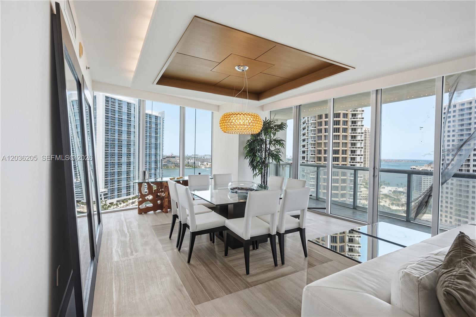 A modern dining room features a glass table, white chairs, and floor-to-ceiling windows overlooking buildings — 465 Brickell Ave # 2101, Miami FL 33131, MIAMI, FL