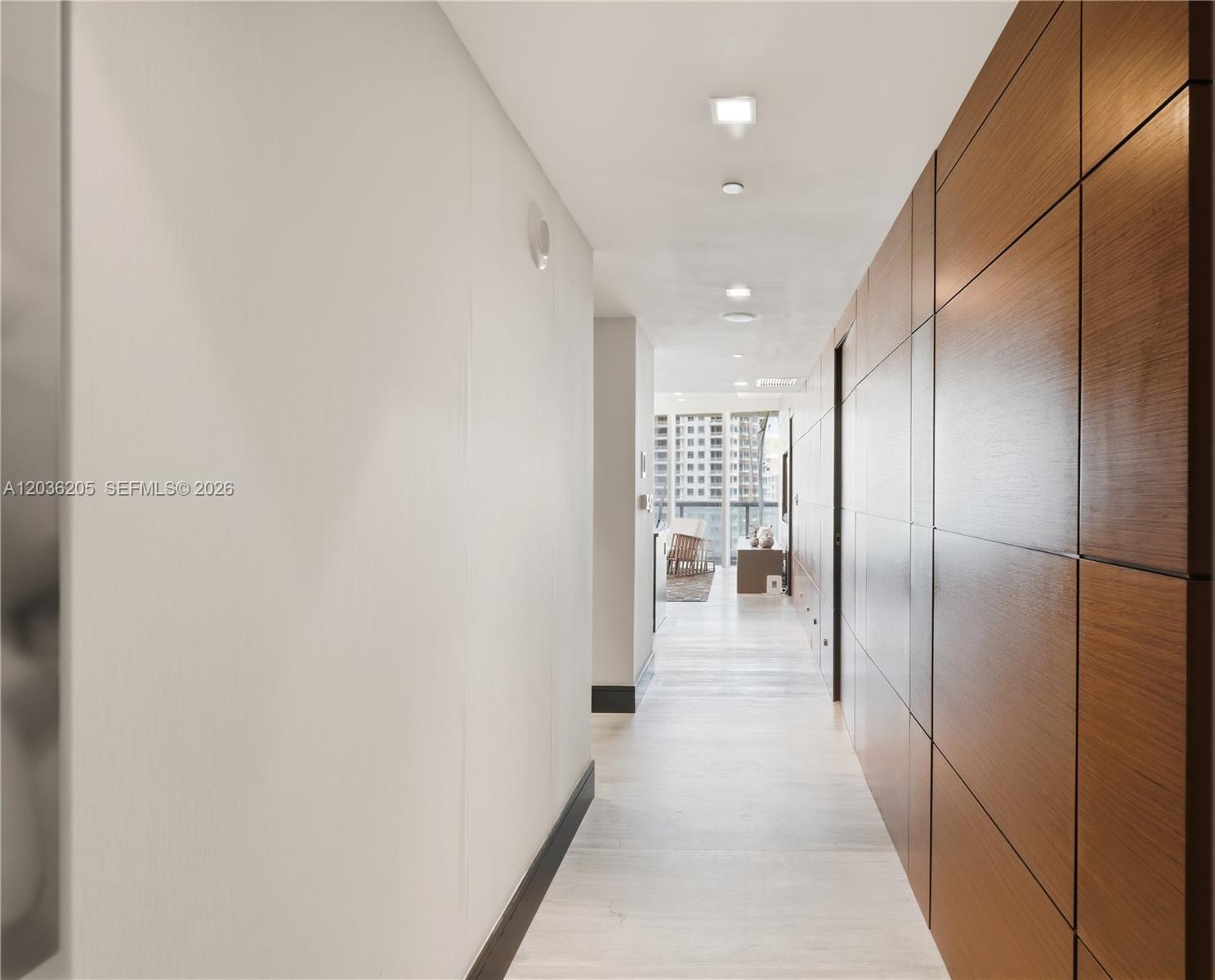 A hallway features light wood flooring, white walls, and a paneled wood accent wall — 465 Brickell Ave # 2101, Miami FL 33131, MIAMI, FL