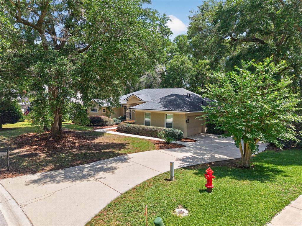 A single-story house with a concrete driveway and a red fire hydrant in the yard — 4525 SE 48TH PLACE ROAD, OCALA, FL