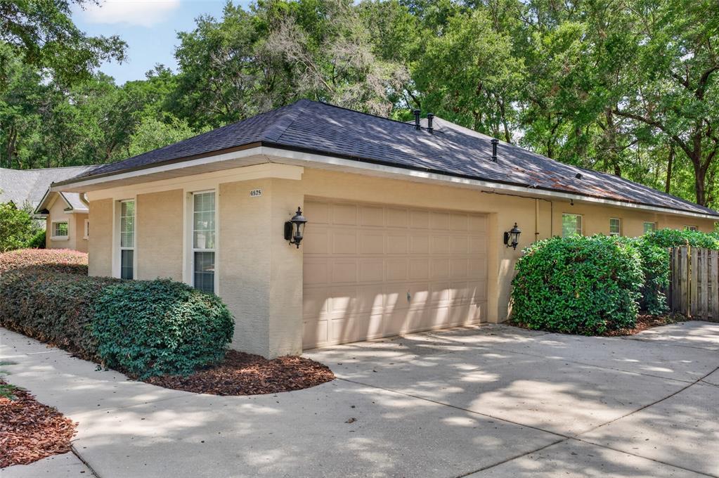 A tan stucco house with a two-car garage and a dark shingled hip roof — 4525 SE 48TH PLACE ROAD, OCALA, FL