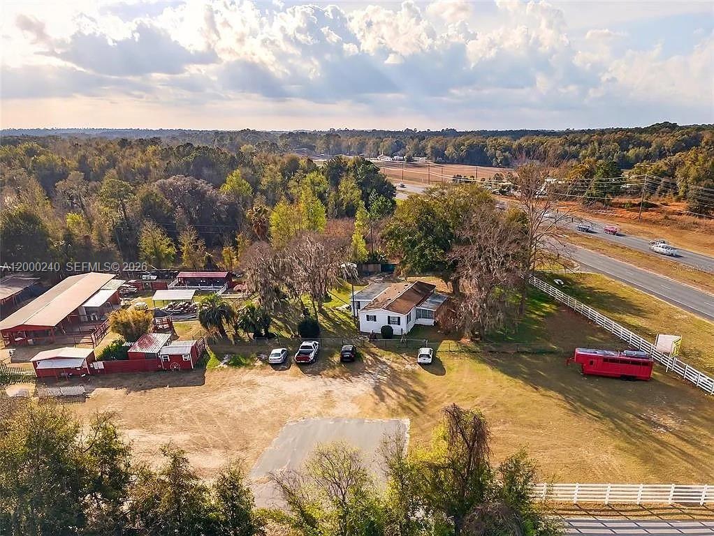 An aerial view shows a house, several outbuildings, and a red trailer on a rural lot — 11150 W Highway 40, Ocala FL 34482-6840, OCALA, FL