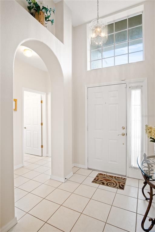 An entryway features a white door, a tiled floor, an arched opening, and a tall window — 223 RIDGE VIEW DRIVE, DAVENPORT, FL