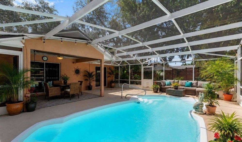 A screened-in patio features a swimming pool, outdoor seating area, and potted plants — 10825 BEVERLY COURT, CLERMONT, FL