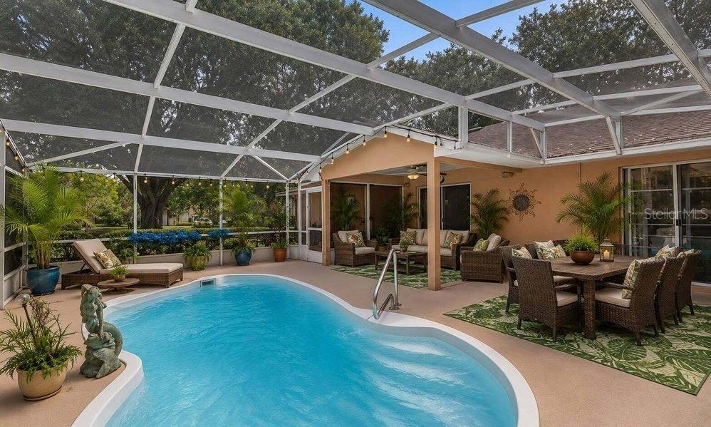 A screened-in patio features a swimming pool, outdoor dining area, and lounge furniture — 10825 BEVERLY COURT, CLERMONT, FL