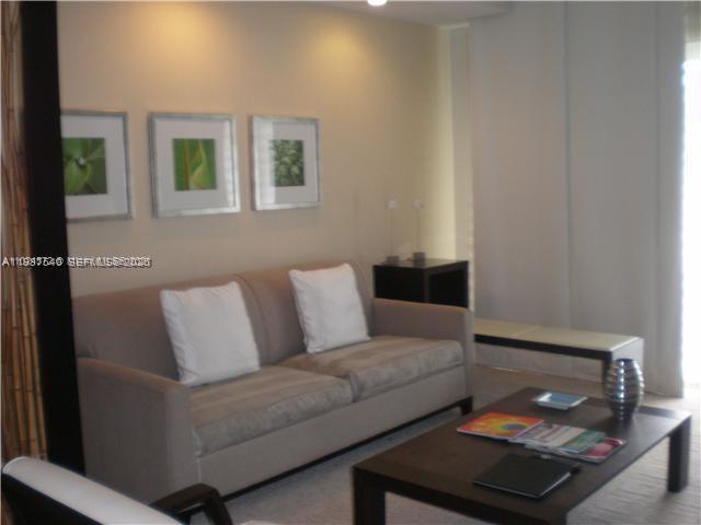 A living room features a beige sofa, a dark wood coffee table, and three framed prints — 5300 NW 87 Avenue # 406, Doral FL 33178, DORAL, FL