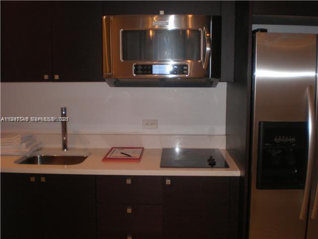 A modern kitchen features dark cabinets, stainless steel appliances, and a white countertop — 5300 NW 87 Avenue # 406, Doral FL 33178, DORAL, FL