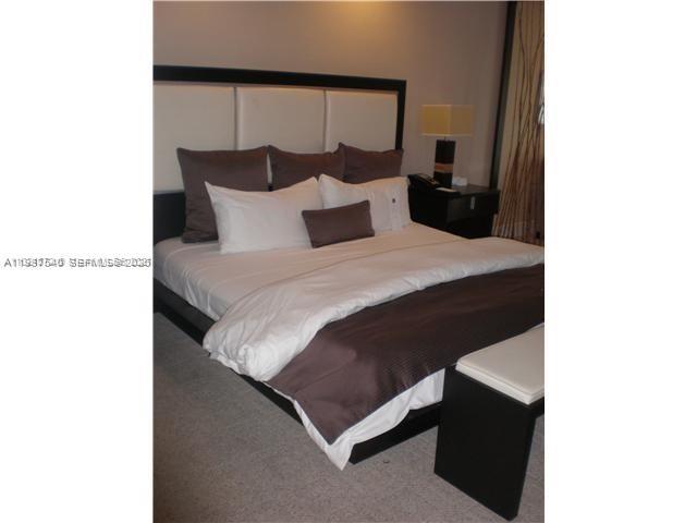 A bedroom features a king-sized bed with a white headboard and dark brown bedding — 5300 NW 87 Avenue # 406, Doral FL 33178, DORAL, FL