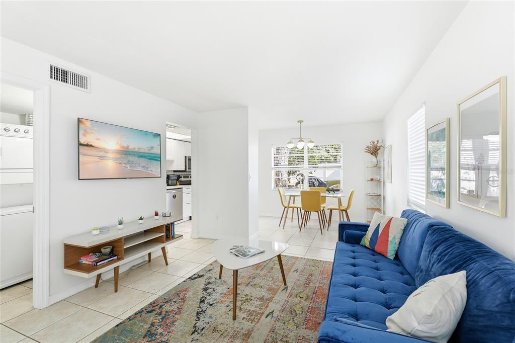 A living room with a blue sofa, white media console, and an adjacent dining area — 1610 & 1612 N ORANGE AVENUE, SARASOTA, FL