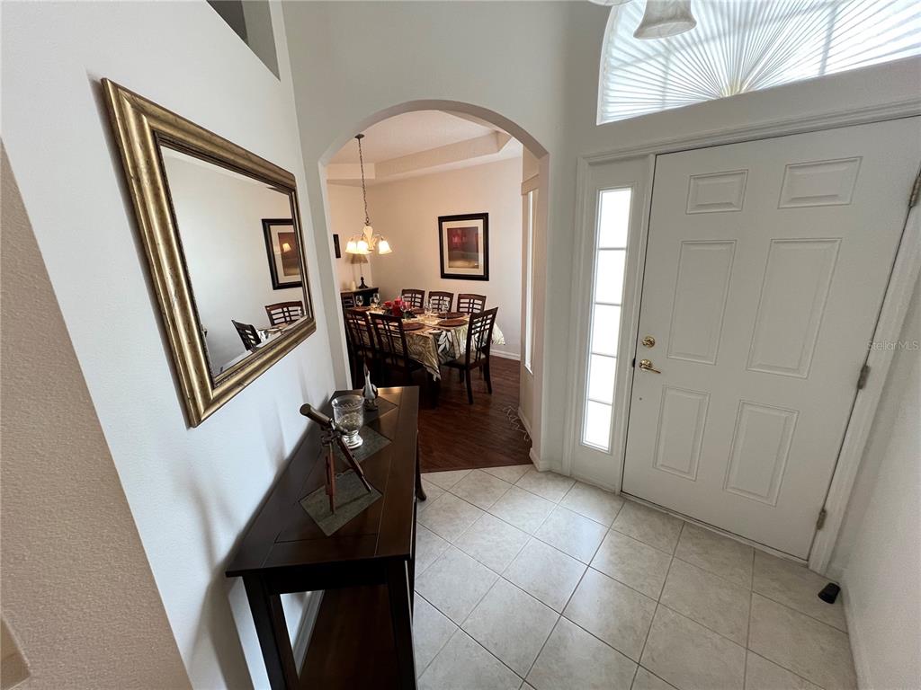 A tiled foyer leads to a dining room through an arched doorway — 176 MINNIEHAHA CIRCLE, HAINES CITY, FL