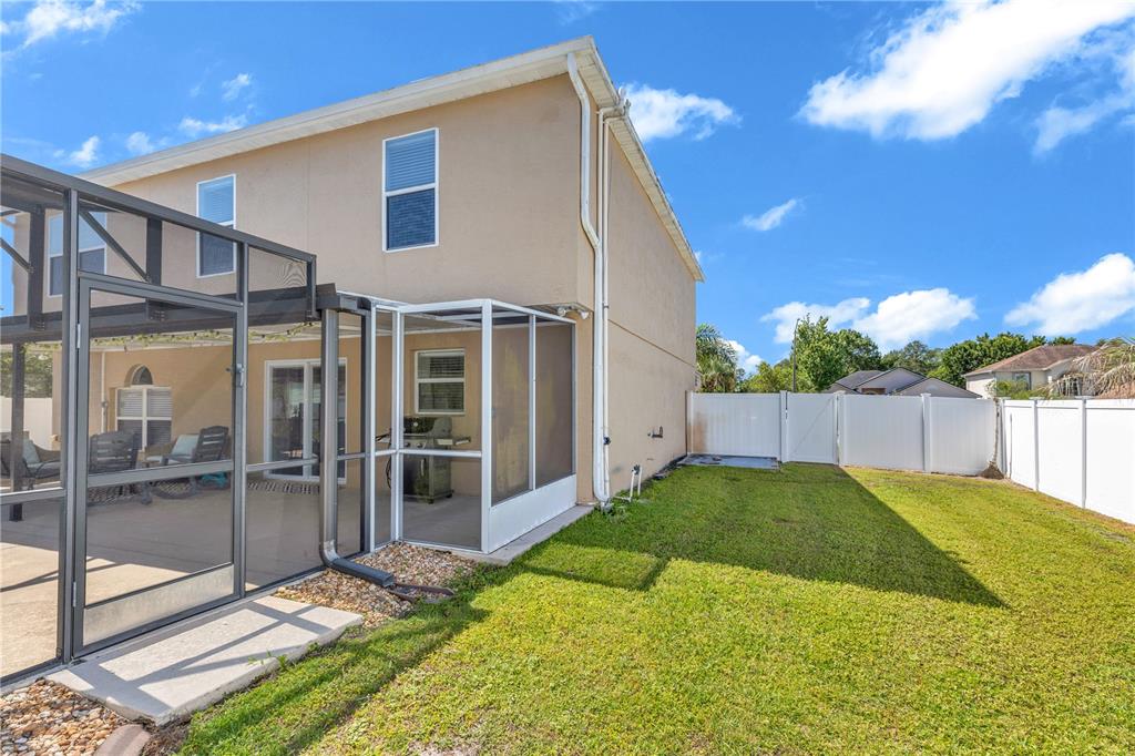 The exterior of a two-story house features a screened-in patio and a fenced backyard — 1874 CORNER MEADOW CIRCLE, ORLANDO, FL