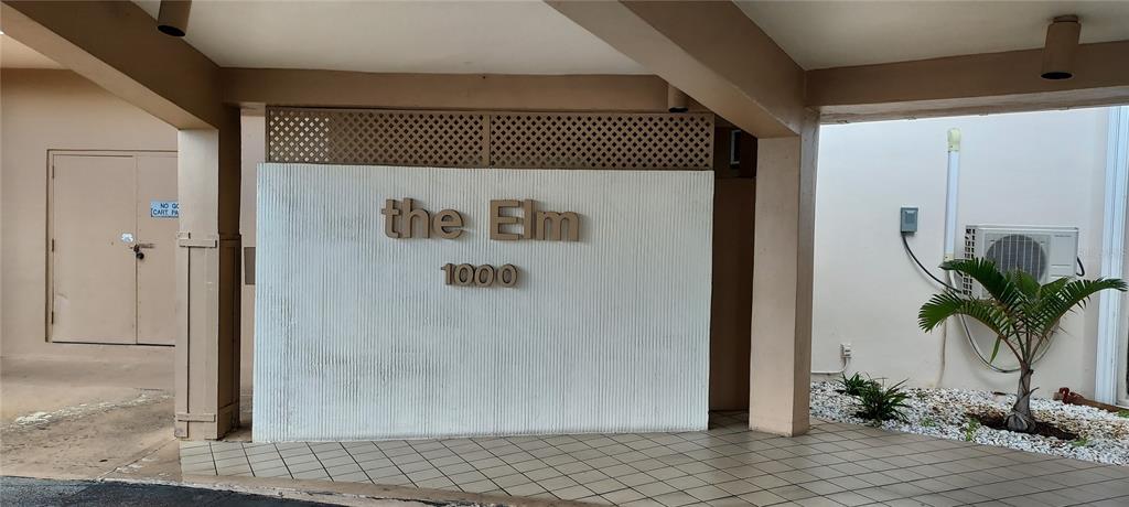 A covered entrance features a sign reading "the Elm 1000" on a textured wall — 1000 SAINT CHARLES PLACE UNIT 209, PEMBROKE PINES, FL