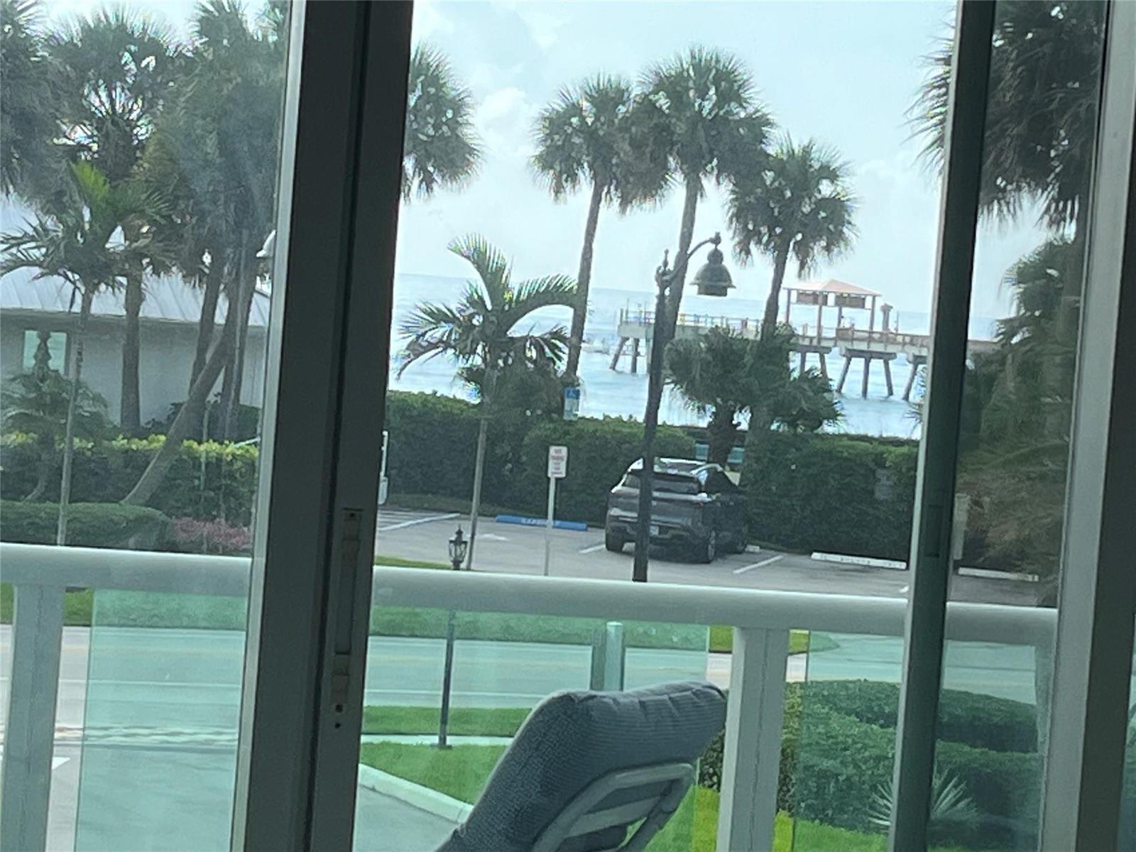 A view of a parking lot, palm trees, and a pier from a balcony — 333 NE 21st Avenue # 318, Deerfield Beach FL 33441, DEERFIELD BEACH, FL