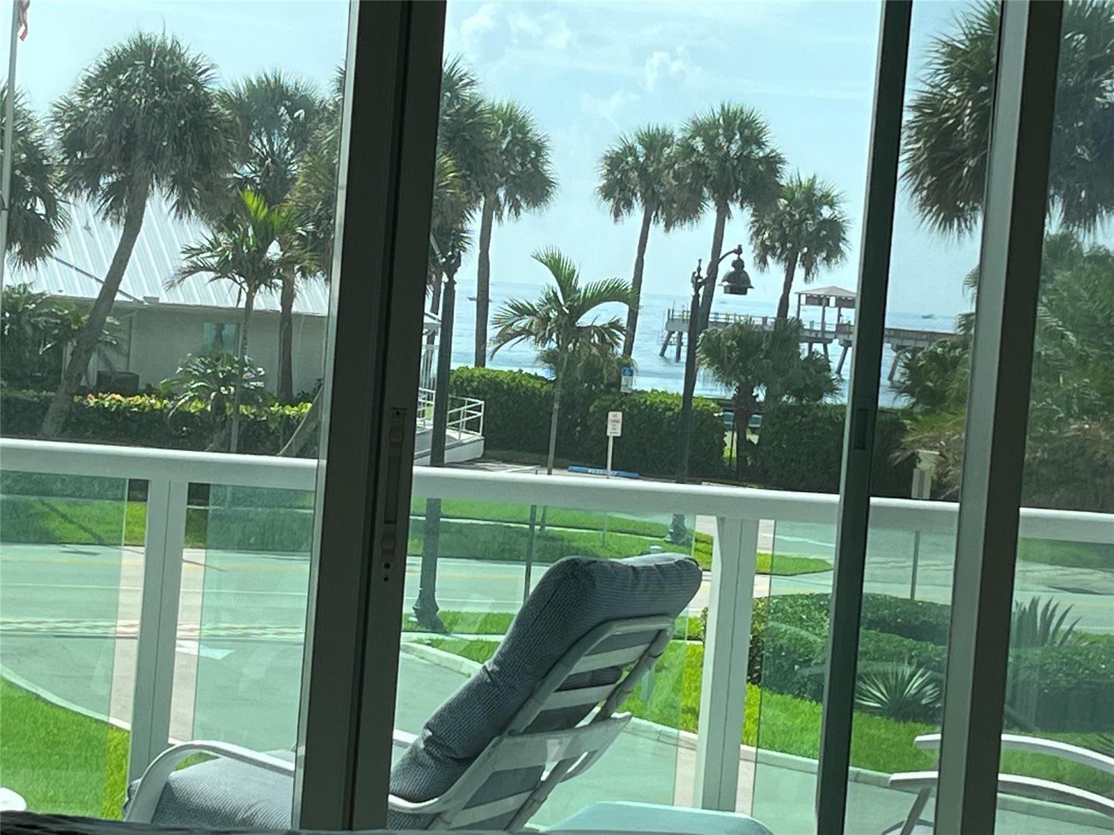 A view from a balcony looking out toward palm trees, a pier, and the ocean — 333 NE 21st Avenue # 318, Deerfield Beach FL 33441, DEERFIELD BEACH, FL