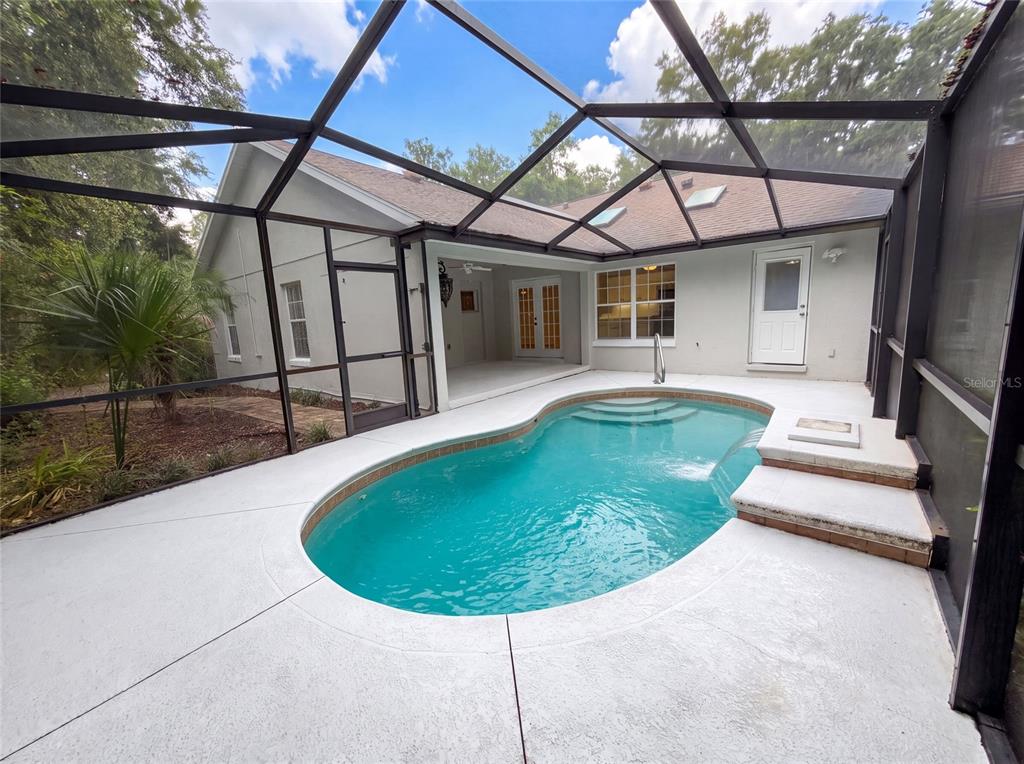 A screened-in patio features a swimming pool with steps and a covered seating area — 11540 CAMP DRIVE, DUNNELLON, FL