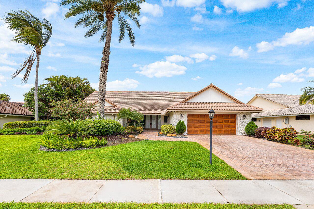 A single-story house with a tiled roof, brick driveway, and palm trees in the front yard — 4382 White Cedar Lane, Delray Beach FL 33445, DELRAY BEACH, FL