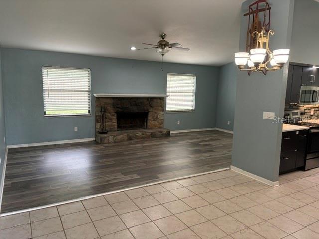 A living room features a stone fireplace, wood-look flooring, and a ceiling fan — 3514 NW 110TH TERRACE, GAINESVILLE, FL