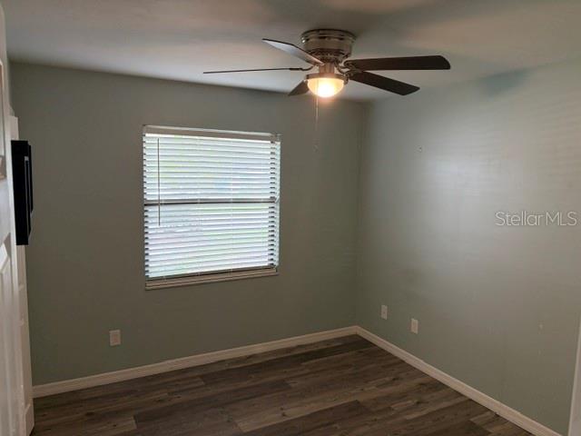 A bedroom with light green walls, wood-look flooring, a ceiling fan, and a window — 3514 NW 110TH TERRACE, GAINESVILLE, FL