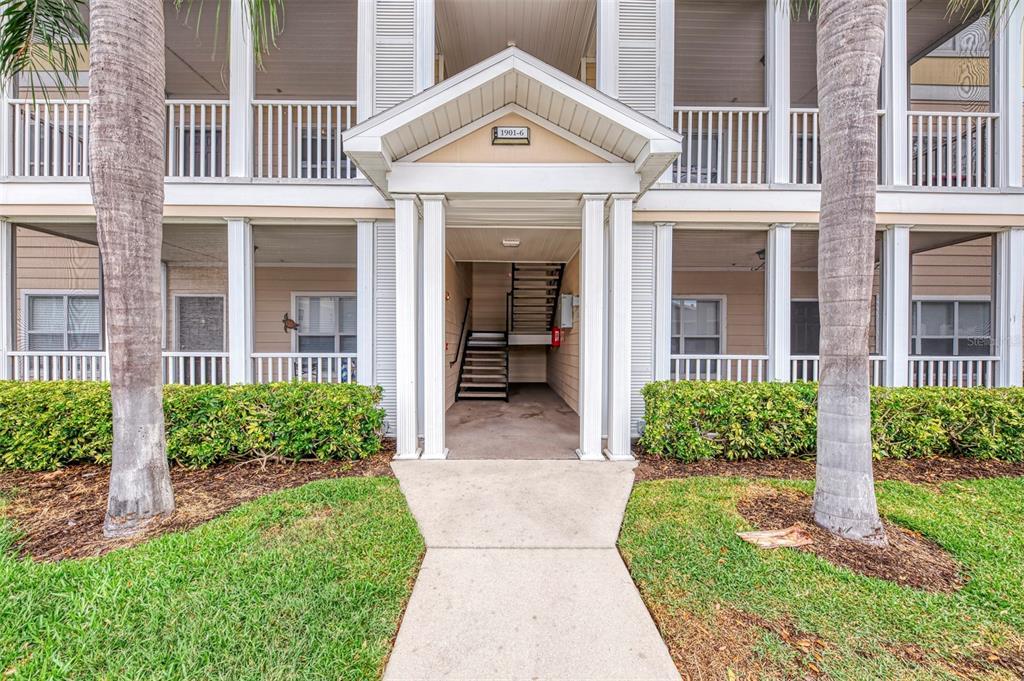 A concrete walkway leads to the covered entrance of a two-story apartment building — 4802 51ST STREET W UNIT 1903, BRADENTON, FL
