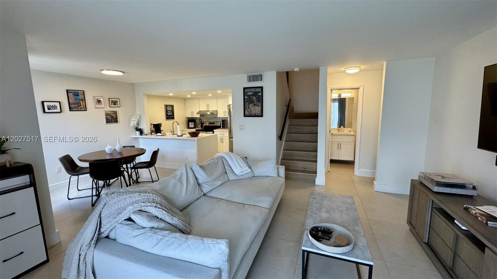 This open-concept living area features a kitchen, dining space, staircase, and light-colored tile flooring — 4540 SW 68th Ct Cir # 7, Miami FL 33155, MIAMI, FL