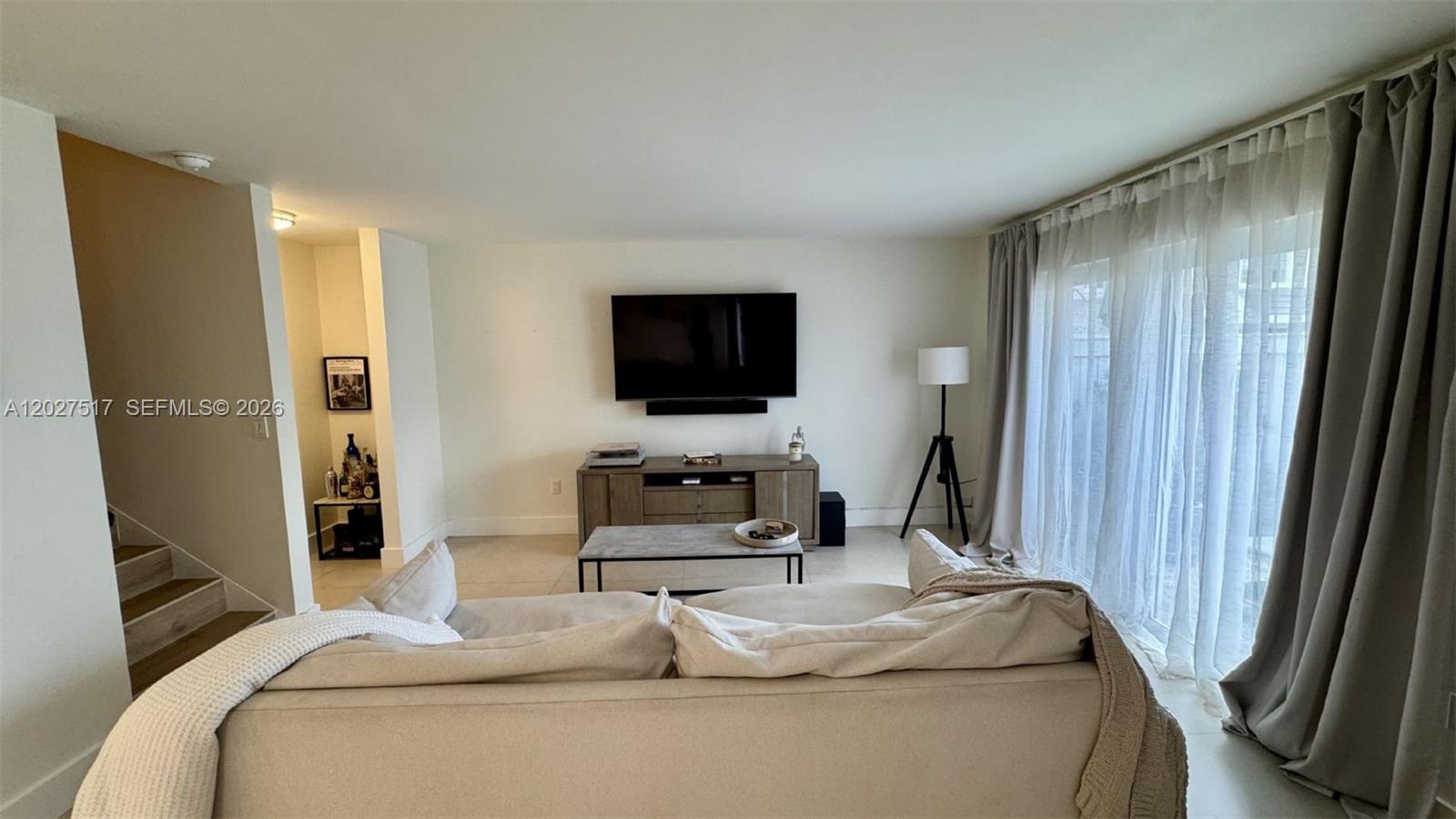 A living room features a wall-mounted television, a media console, and a light-colored sofa — 4540 SW 68th Ct Cir # 7, Miami FL 33155, MIAMI, FL