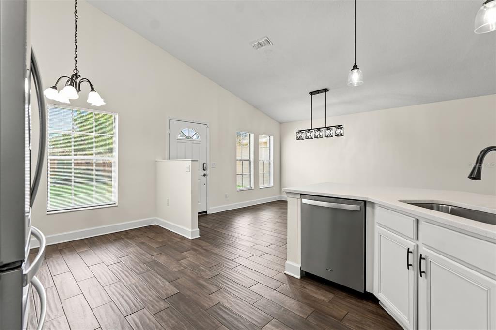 A kitchen with white cabinets, stainless steel appliances, and wood-look tile flooring — 2608 DECK AVENUE, KISSIMMEE, FL