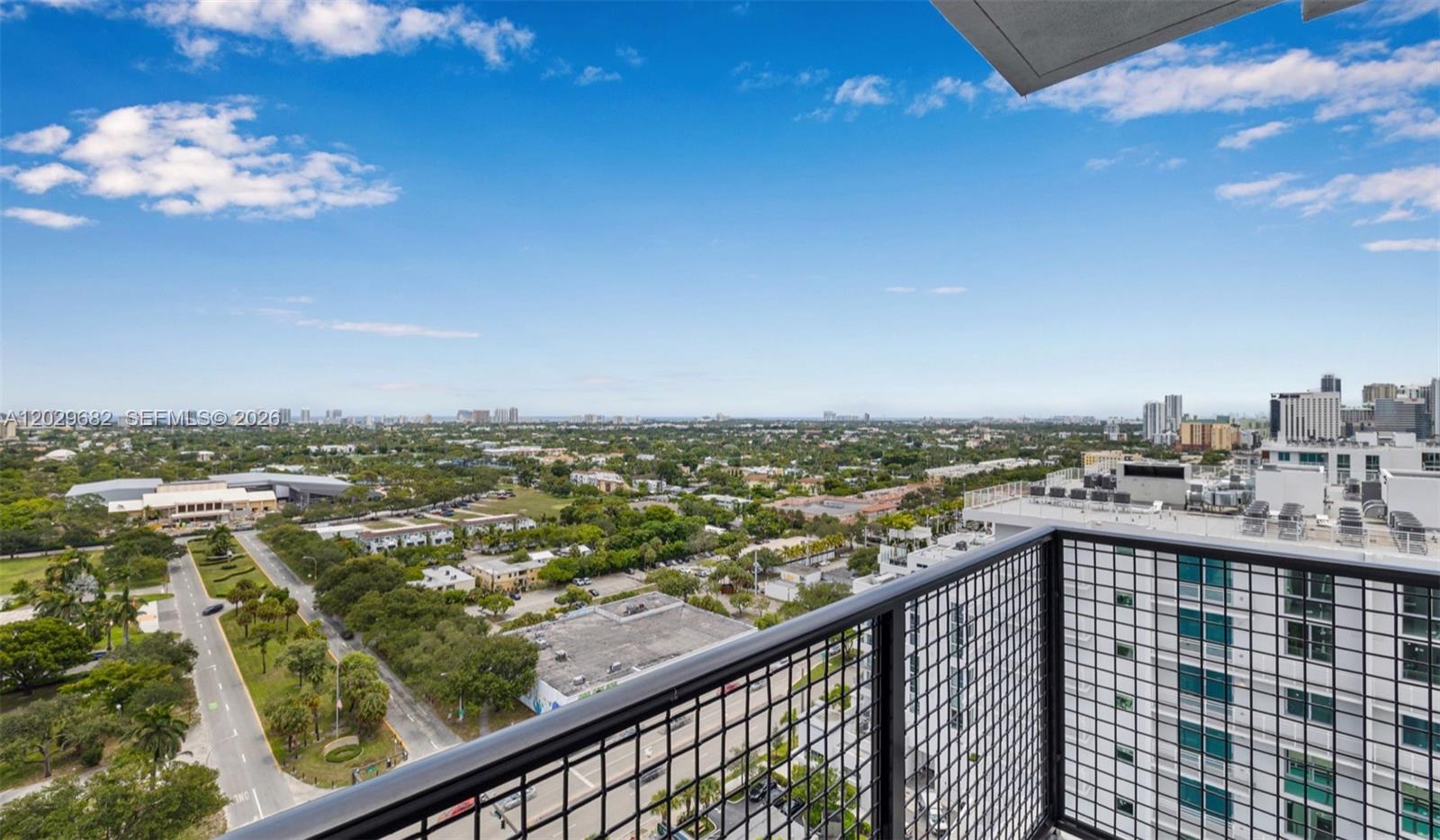 A high-angle view from a balcony overlooking a city landscape with trees and buildings — FORT LAUDERDALE, FL
