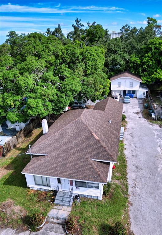 An aerial view shows a white house with a brown shingled roof and a driveway — 1514 12TH AVENUE W, BRADENTON, FL