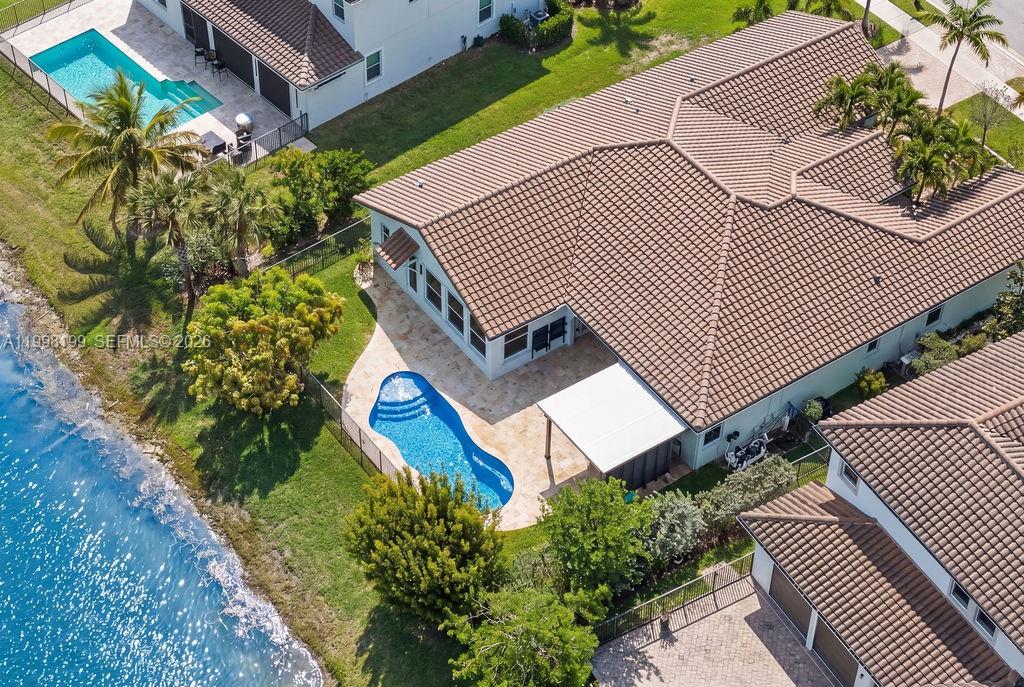 An aerial view shows a house with a tiled roof, a pool, and a patio — 8055 NW 117th Way, Parkland FL 33076, PARKLAND, FL