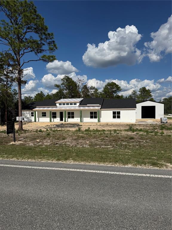 A newly constructed white house with a detached garage sits on a rural lot — 13989 SW 89TH STREET, DUNNELLON, FL