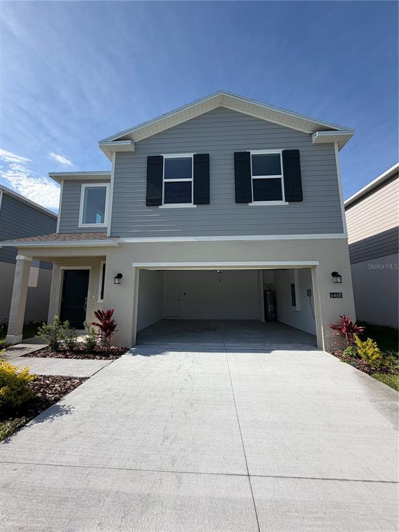 A two-story house features gray horizontal siding, a two-car garage, and a small front porch — 6468 DOMIZIO DRIVE, WINTER HAVEN, FL
