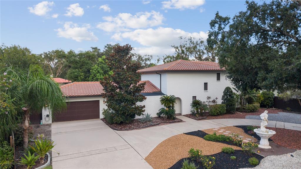 A two-story white stucco house with a tile roof, garage, and landscaped front yard — 403 WEEBURN ROAD, TEMPLE TERRACE, FL