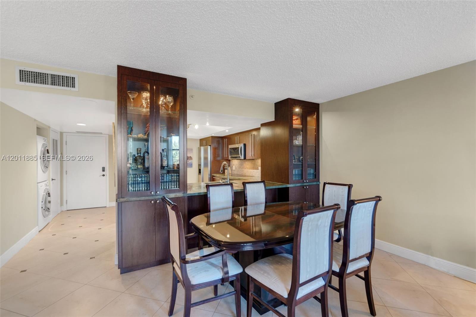 A dining area features a dark wood hutch, a glass-topped table, and tiled flooring — 2900 NE 14th St Cswy # 402, Pompano Beach FL 33062, POMPANO BEACH, FL