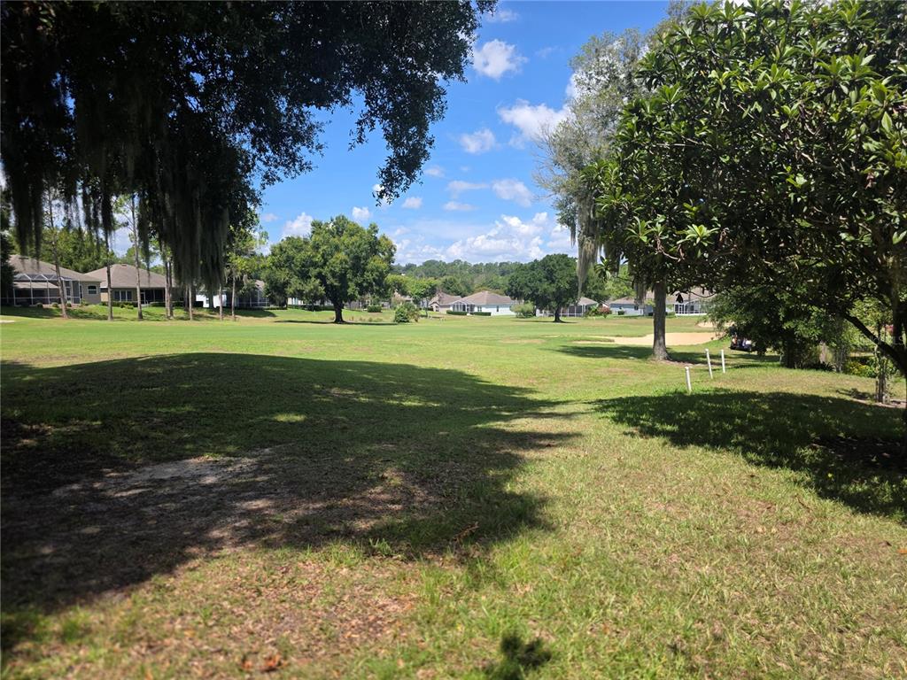 A view of a grassy golf course fairway surrounded by trees and residential houses — 2131 SAINT IVES COURT, CLERMONT, FL