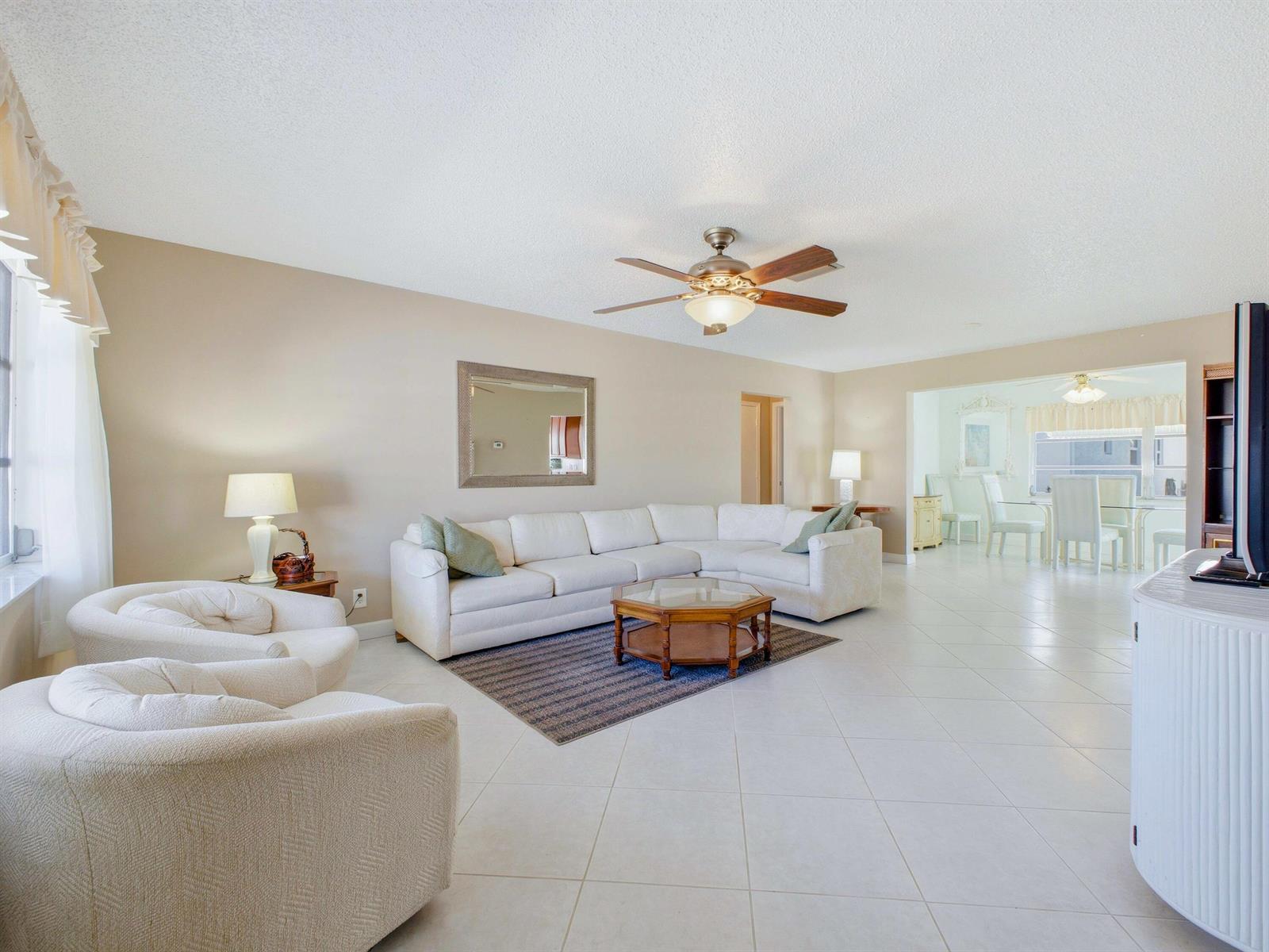 A living room with white tile floors, a sectional sofa, two armchairs, and a ceiling fan — 2020 SW 17th Avenue, Boynton Beach FL 33426, BOYNTON BEACH, FL