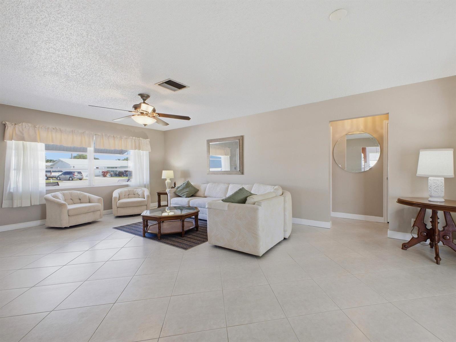 A living room features light tile floors, a white sectional sofa, and a ceiling fan — 2020 SW 17th Avenue, Boynton Beach FL 33426, BOYNTON BEACH, FL
