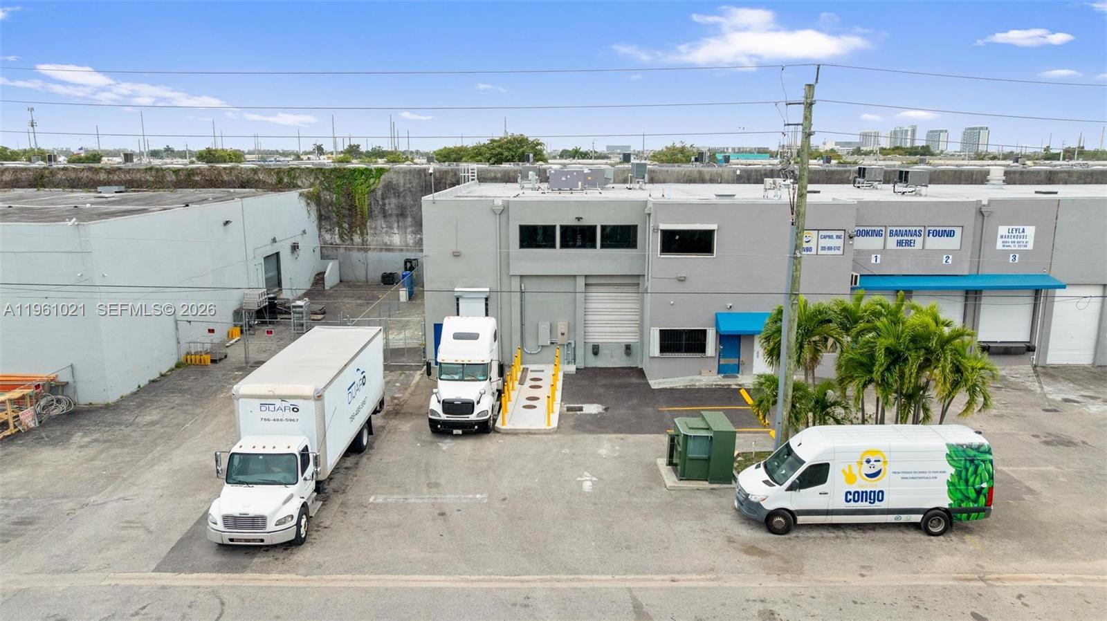An aerial view shows a commercial warehouse building with two trucks and a van parked outside — 8000 NW 68th St, Medley FL 33166, MEDLEY, FL