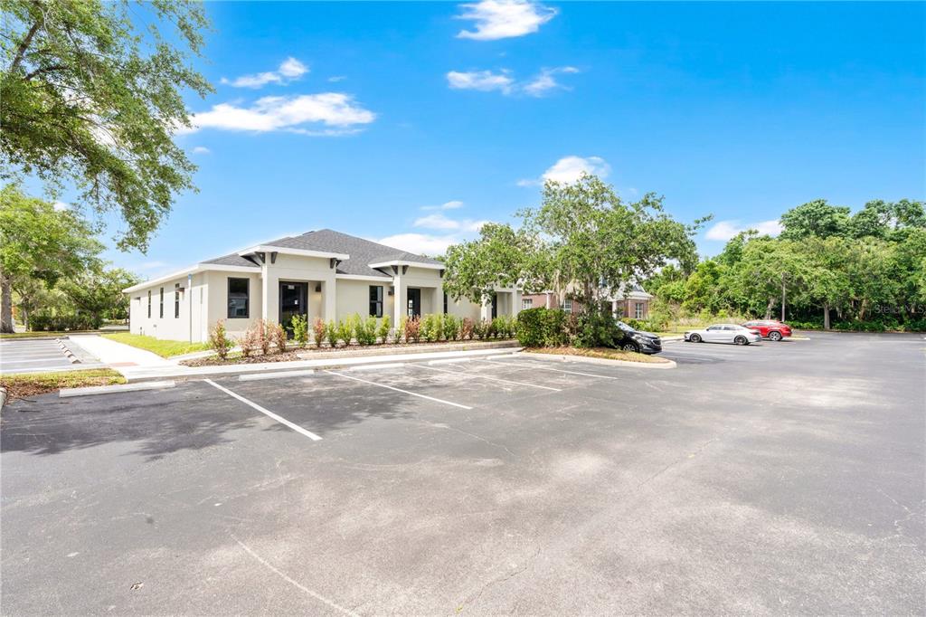 A single-story commercial building with a parking lot in front under a blue sky — 1300 LEXINGTON GREEN LANE, SANFORD, FL