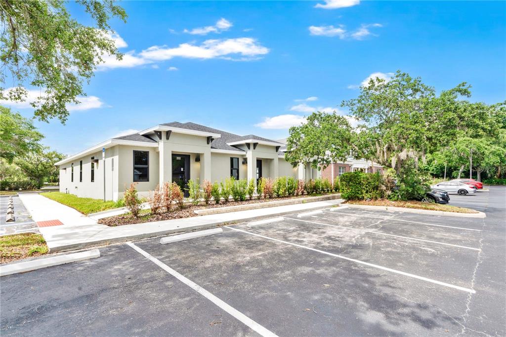 A single-story commercial building with a parking lot and landscaping under a blue sky — 1300 LEXINGTON GREEN LANE, SANFORD, FL