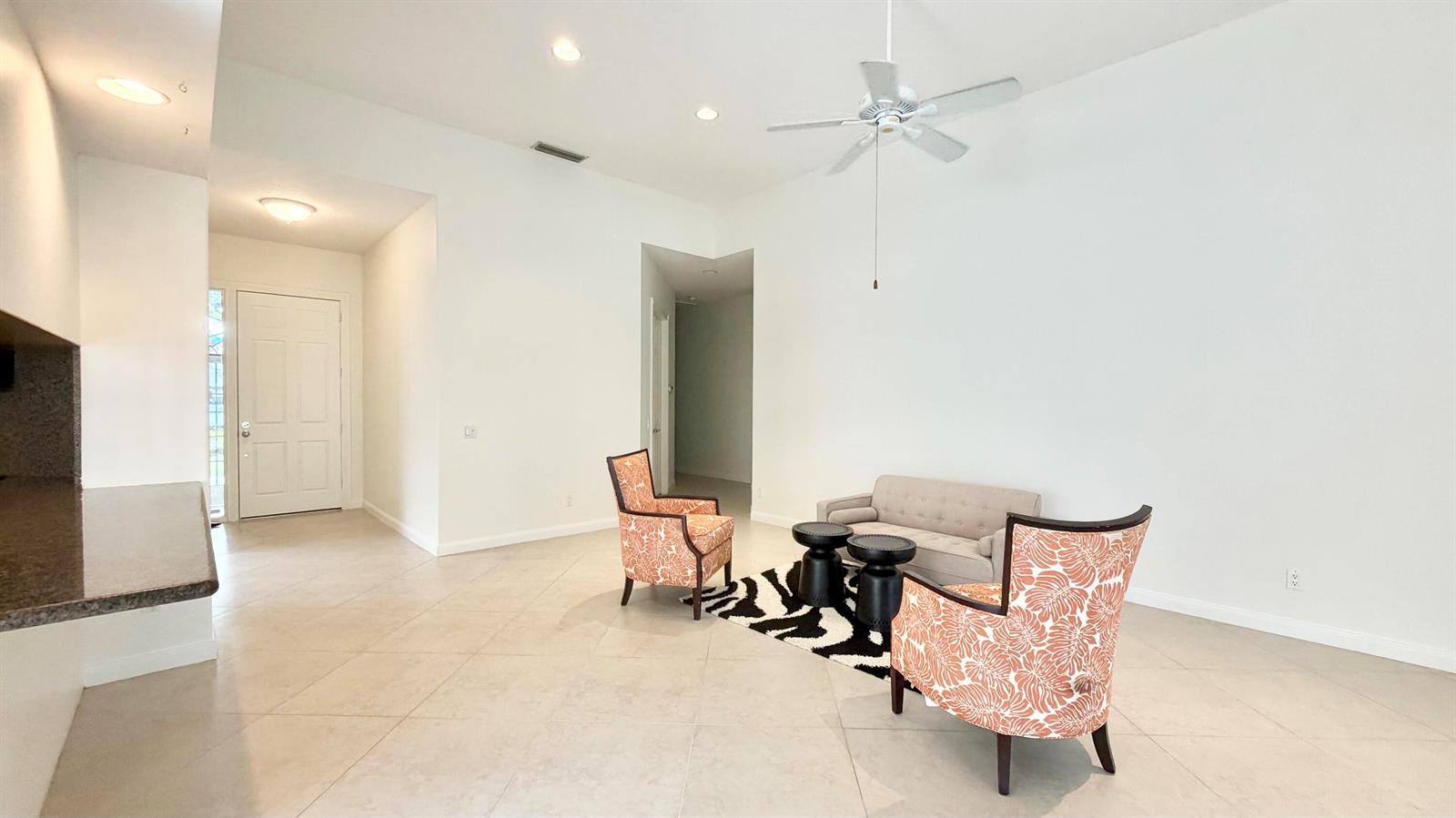 A living room with tile floors, a ceiling fan, and a small seating arrangement — 2704 Irma Lake Drive, West Palm Beach FL 33411, WEST PALM BEACH, FL
