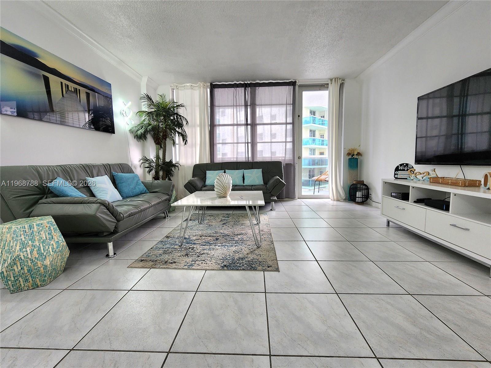A living room features two gray sofas, a white coffee table, and tile flooring — 3725 S Ocean Dr # 620, Hollywood FL 33019, HOLLYWOOD, FL